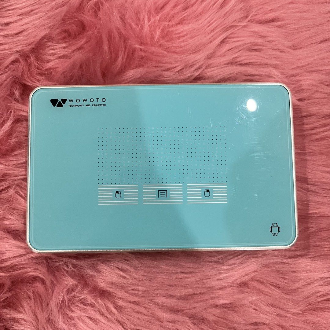 WOWOTO Mini Projector with Remote, Tripod, and Accessories (Category: Projectors) located in Caloocan City. Submitted by lovedbychin_ (Listing ID 1456911422, Image 3). Description: - WOWOTO Mini Projector: Compact and portable for entertainment on the go. - Includes: Remote control, flexible tripod, power adapter, and protective sleeve. - Connectivity: HDMI/MHL, USB ports, and micro SD card slot. - Ideal for: Movie nights, presentations, and more