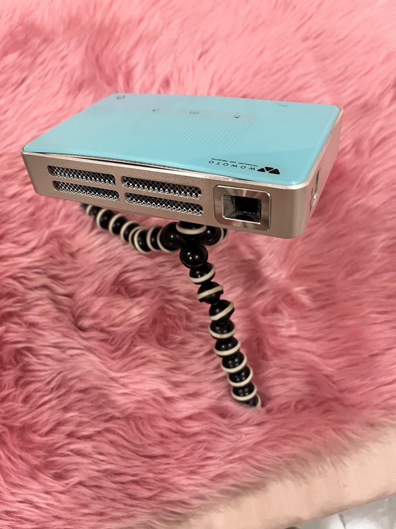 WOWOTO Mini Projector with Remote, Tripod, and Accessories (Category: Projectors) located in Caloocan City. Submitted by lovedbychin_ (Listing ID 1456911422, Image 1). Description: - WOWOTO Mini Projector: Compact and portable for entertainment on the go. - Includes: Remote control, flexible tripod, power adapter, and protective sleeve. - Connectivity: HDMI/MHL, USB ports, and micro SD card slot. - Ideal for: Movie nights, presentations, and more