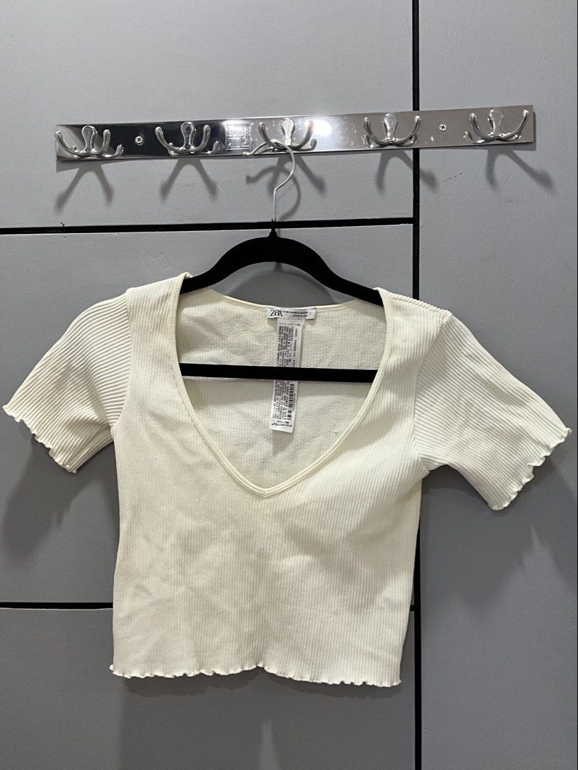 Zara Ribbed Cropped V-Neck Top Cream (Category: Sleeveless) located in Manila. Submitted by shopmrld (Listing ID 1456936411, Image 1). Description: - Cream ribbed cropped top from Zara - Short sleeves with lettuce hem details - V-neckline - Stretchy material - Size on tag : XS-S - Can fit upto Semi-M.