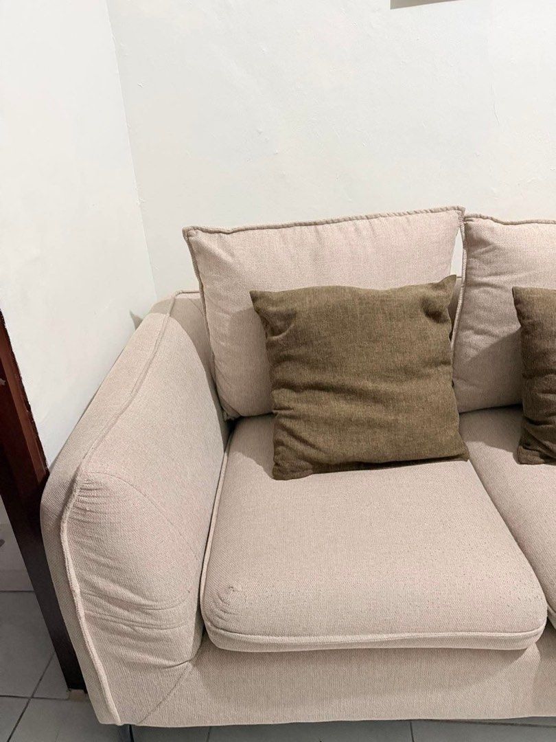 2-Seater Beige Sofa with Throw Pillows (Category: Sofas) located in Manila. Submitted by ellebarbacion (Listing ID 1457108812, Image 3). Description: - Comfortable 2-seater sofa - Neutral beige fabric - Comes with two dark brown throw pillows - Clean lines with modern black legs - Fits well in most living spaces - Ideal for apartments or smaller rooms - Ready for a new home.