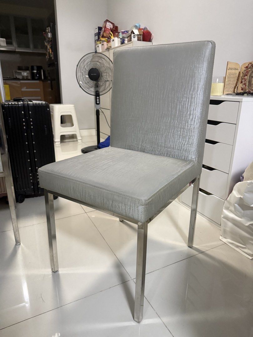 4-Seater Dining Table Set with Upholstered Chairs (Category: Tables & Sets) located in Manila. Submitted by annamart (Listing ID 1457044680, Image 3). Description: Includes: - 1 white rectangular dining table - 4 upholstered dining chairs with silver-gray fabric upholstery - Stainless-finish frames Pre-owned with normal signs of use, including minor surface marks on tabletop. In good overall condition. Selling as a complete set. Dimensions: Table