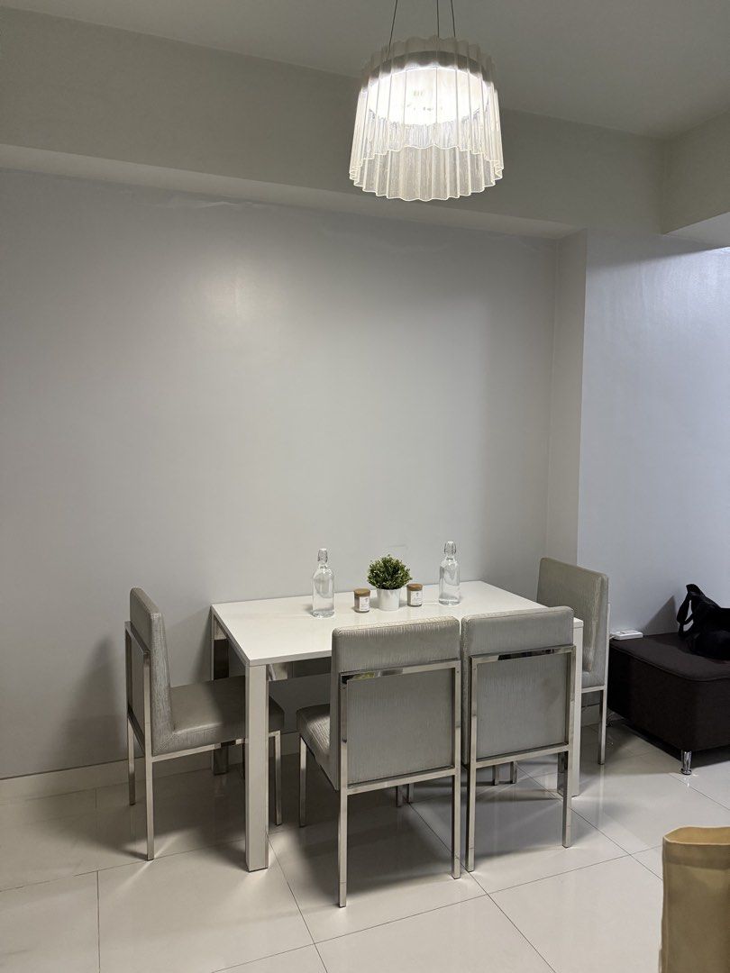4-Seater Dining Table Set with Upholstered Chairs (Category: Tables & Sets) located in Manila. Submitted by annamart (Listing ID 1457044680, Image 2). Description: Includes: - 1 white rectangular dining table - 4 upholstered dining chairs with silver-gray fabric upholstery - Stainless-finish frames Pre-owned with normal signs of use, including minor surface marks on tabletop. In good overall condition. Selling as a complete set. Dimensions: Table