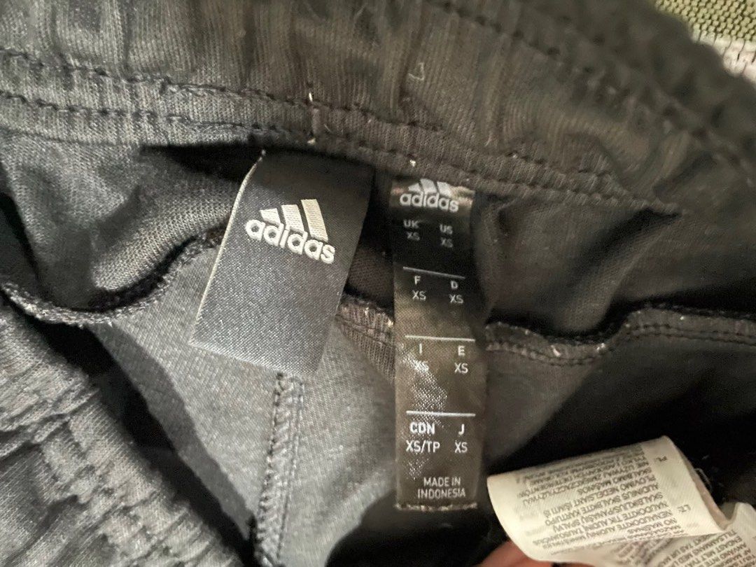 Adidas Black Track Pants with White Stripes (Category: Activewear) located in Dumaguete. Submitted by han_heuinanta (Listing ID 1457034810, Image 2). Description: - Black Adidas track pants - Size XS - Classic white three stripes down the sides - Drawstring waist for adjustable fit - Zippered pockets for secure storage - Made in Indonesia Negotiable.