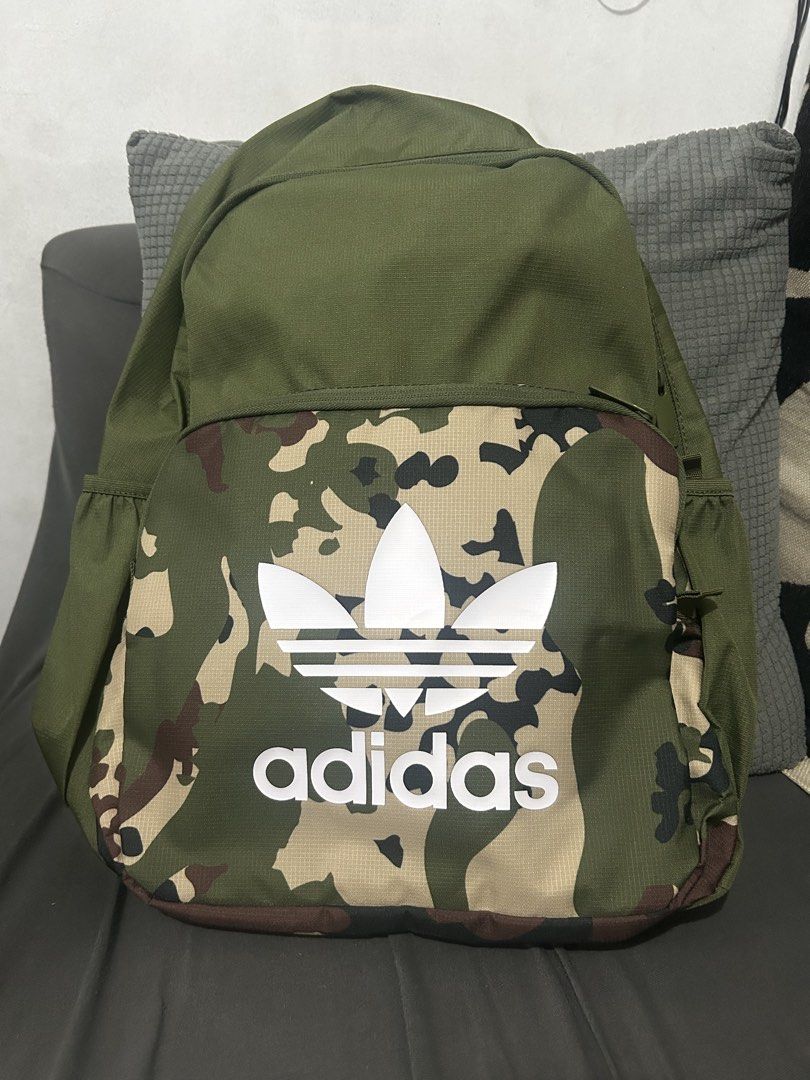 Adidas Camouflage Backpack (Category: Backpacks) located in Manila. Submitted by jeremywayn81052 (Listing ID 1457068697, Image 1). Description: - Stylish green and tan Adidas camouflage backpack. - Features the iconic white Adidas trefoil logo on the front. - Includes convenient side pockets for extra storage. - Secure zip closure for all your belongings. - Ideal for school, college, or everyday adventures..