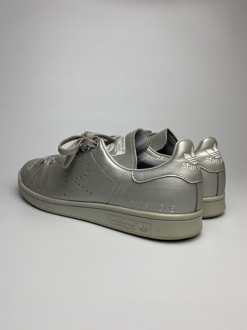 Adidas Raf Simons Stan Smith Metallic Silver Leather Sneakers (Category: Sneakers) located in Lipa City. Submitted by 4217_ (Listing ID 1457010679, Image 3). Description: - Metallic silver Adidas Stan Smith sneakers - Collaboration with Raf Simons - Signature perforated 'R' logo detail - Premium leather upper - Classic lace-up closure - Adds a unique, statement touch to any outfit.