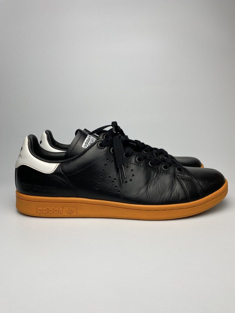Adidas Stan Smith Raf Simons Black Gum Sole (Category: Sneakers) located in Lipa City. Submitted by 4217_ (Listing ID 1457010675, Image 1). Description: - Classic Adidas Stan Smith sneakers - Collaboration with Raf Simons - Black leather upper with white accents - Retro gum sole - Perforated side details - Perfect for casual wear - Shows some signs of wear on sole and leather.