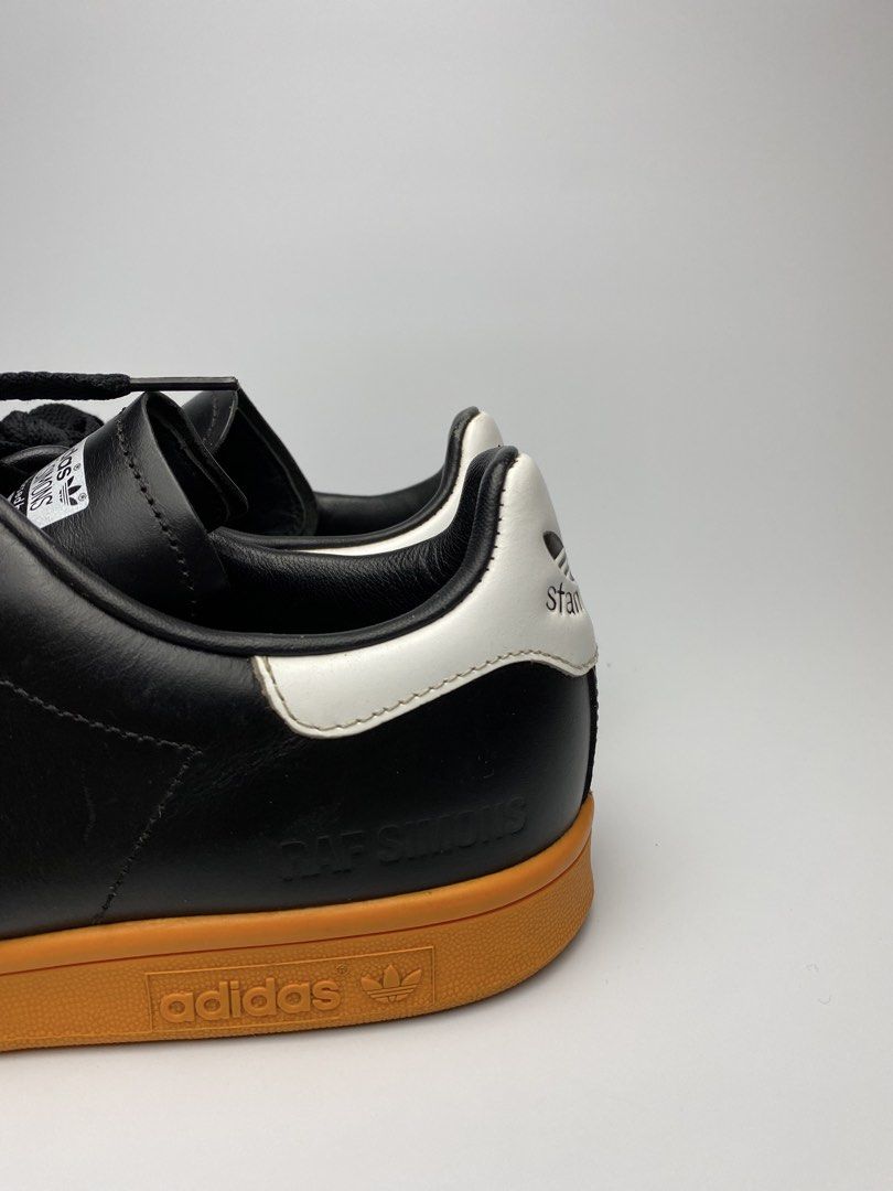 Adidas Stan Smith Raf Simons Black Gum Sole (Category: Sneakers) located in Lipa City. Submitted by 4217_ (Listing ID 1457010675, Image 2). Description: - Classic Adidas Stan Smith sneakers - Collaboration with Raf Simons - Black leather upper with white accents - Retro gum sole - Perforated side details - Perfect for casual wear - Shows some signs of wear on sole and leather.