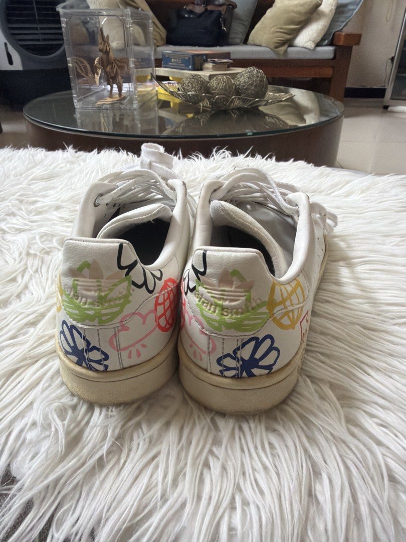 Adidas Stan Smith White Sneakers with Colorful Graphics (Category: Sneakers) located in Quezon City. Submitted by jdecino (Listing ID 1456977926, Image 3). Description: - Classic white Adidas Stan Smith sneakers - Iconic three stripes - Unique colorful graphic design on the heel - White laces - Creamy white soles - Perfect for casual wear - Shows some signs of wear Size: 8 .