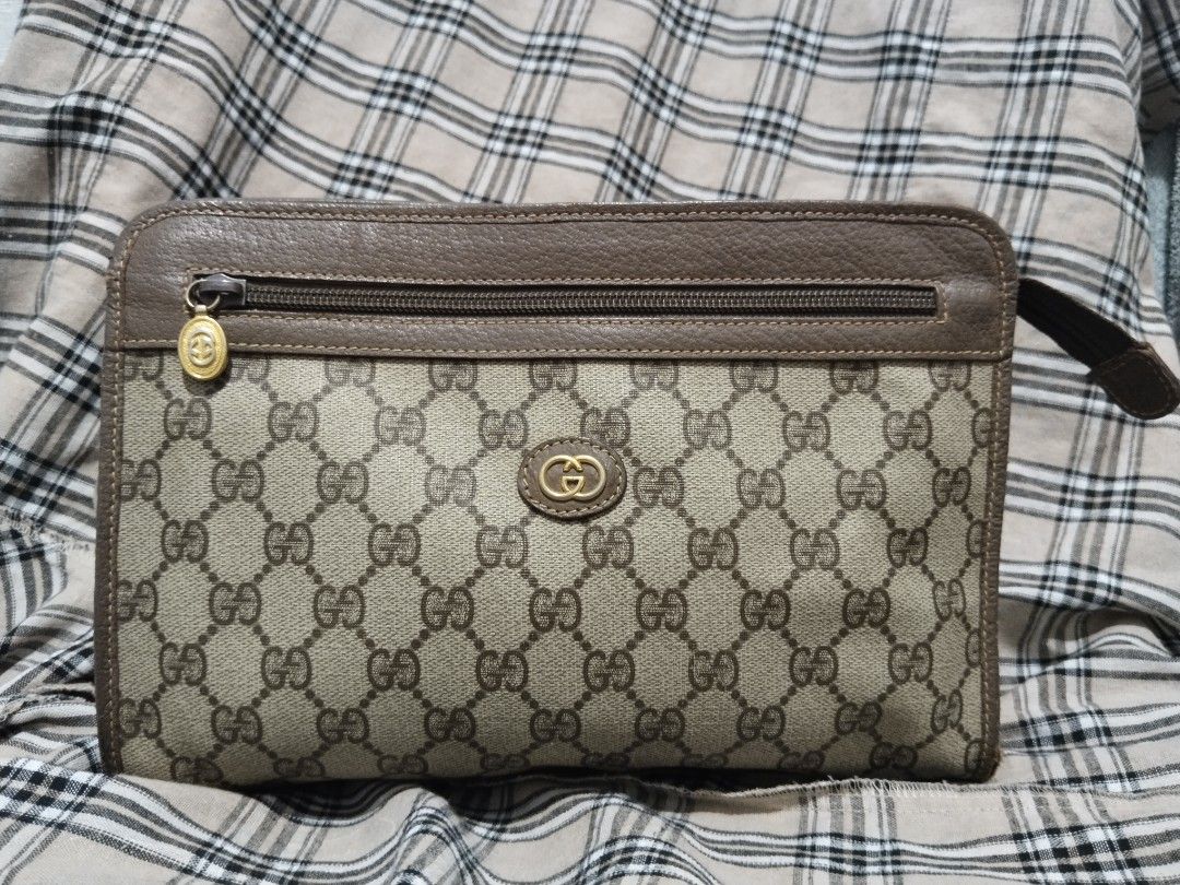 Authentic Gucci Monogram Clutch Bag (Category: Luxury Bags & Wallets) located in Tabaco. Submitted by strain_finds (Listing ID 1457084552, Image 2). Description: - Authentic Gucci clutch - Classic GG monogram canvas with leather trim - Zip top closure - Small wrist strap attached - Perfect for carrying essentials - Shows some signs of wear on leather and canvas, but remains a stylish accessory (Authenticated by Van Mañebog).