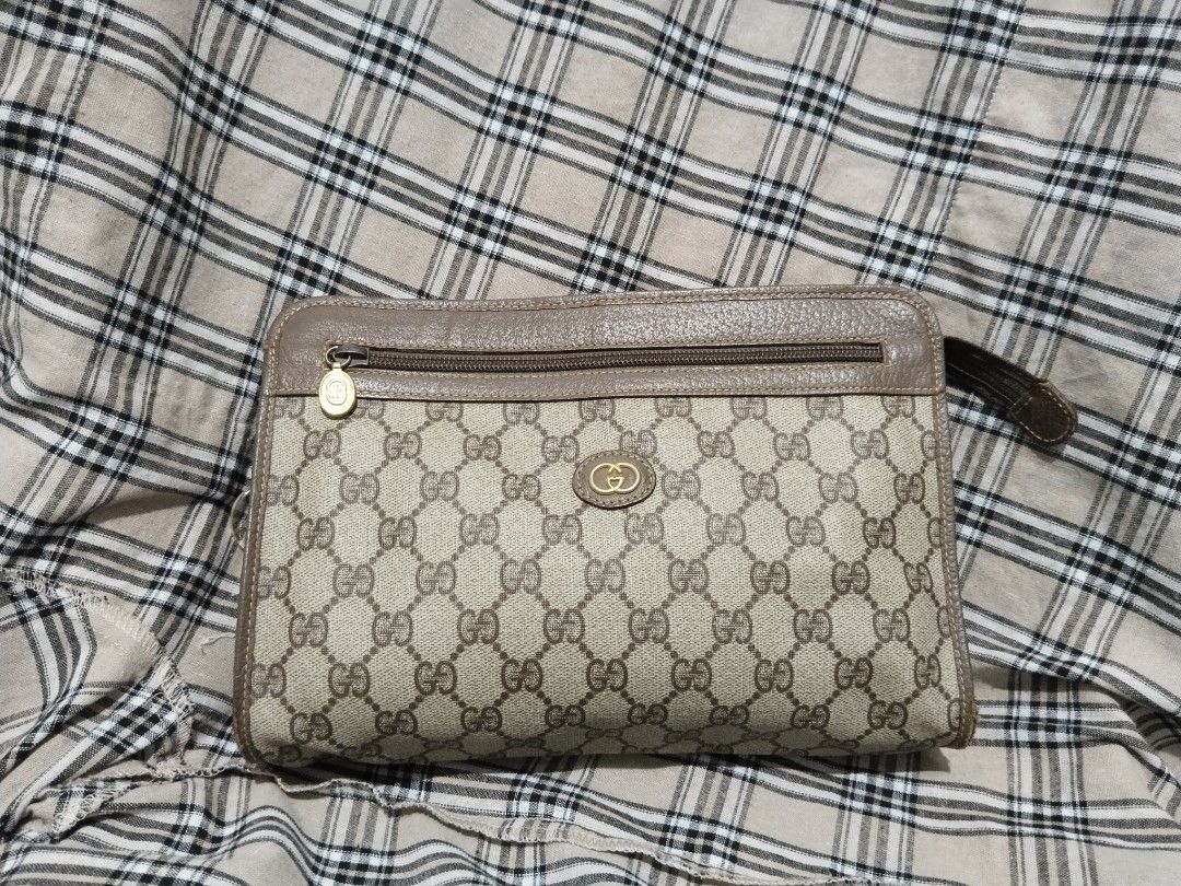 Authentic Gucci Monogram Clutch Bag (Category: Luxury Bags & Wallets) located in Tabaco. Submitted by strain_finds (Listing ID 1457084552, Image 1). Description: - Authentic Gucci clutch - Classic GG monogram canvas with leather trim - Zip top closure - Small wrist strap attached - Perfect for carrying essentials - Shows some signs of wear on leather and canvas, but remains a stylish accessory (Authenticated by Van Mañebog).