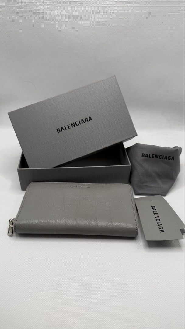 Balenciaga Grey Leather Zip Around Wallet (Category: Luxury Bags & Wallets) located in Pasig City. Submitted by shoptilyoudrop87 (Listing ID 1457133232, Image 1). Description: - Authentic Balenciaga zip around wallet - Color: Grey leather - Features classic Balenciaga logo on the front - Includes original box, dust bag, and authenticity card -Barely noticeable transfer stain as seen in the photo - Ample space for cards and cash - Ideal for everyd