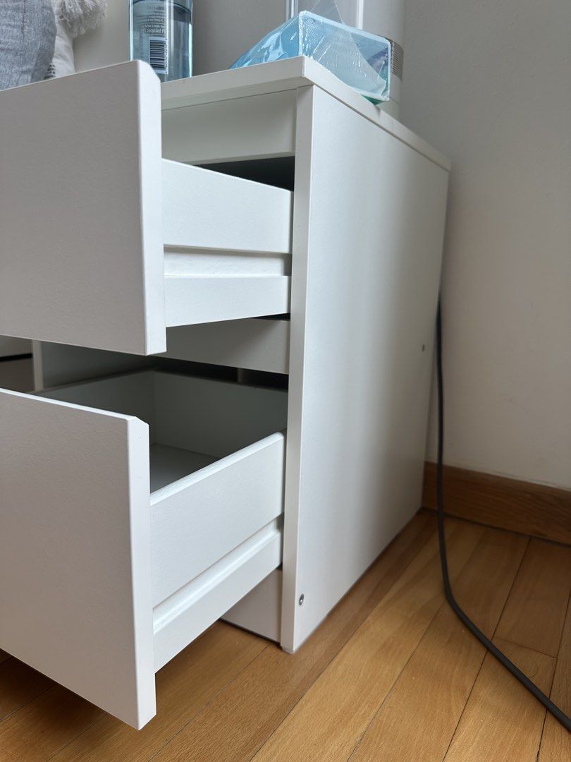 Bed Side Table (Category: Tables & Sets) located in Singapore. Submitted by lealouye (Listing ID 1457001385, Image 3). Description: White bedside table with two drawers. Modern and minimalist design. The inside of the upper drawer is slightly yellowed, but this may be removable with a Cif cleaning product..