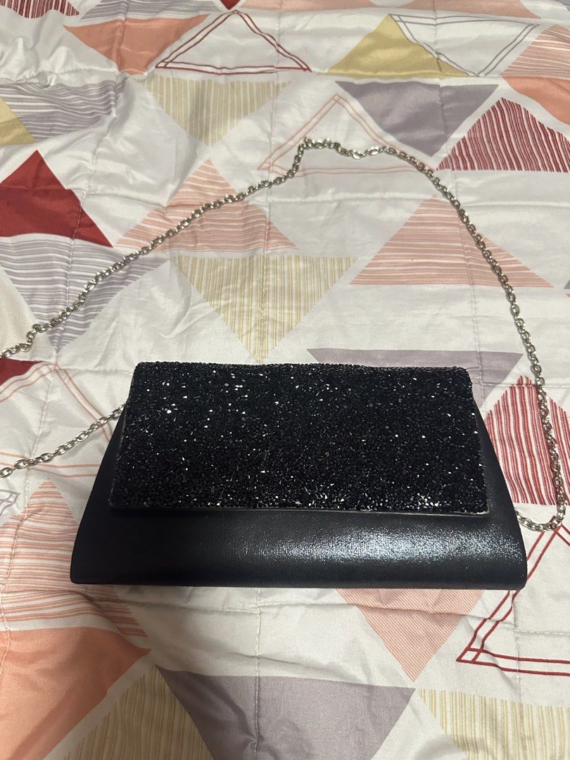 Black Glitter Clutch Bag with Silver Chain (Category: Clutches) located in Pasig City. Submitted by s4sayaki (Listing ID 1457088216, Image 2). Description: - Sparkly black clutch bag - Glittery front flap, smooth black body - Detachable silver chain strap included - Ideal for parties and nights out - Fits essentials: phone, keys, lipstick - Versatile: carry as clutch or wear on shoulder.