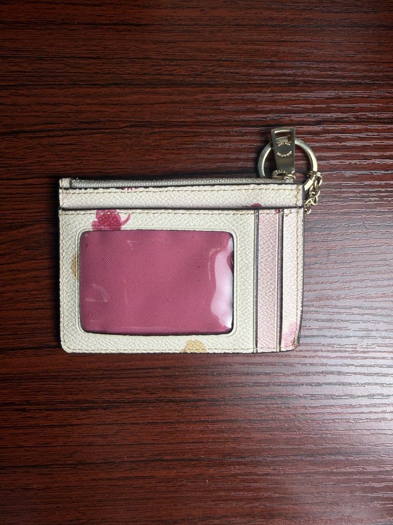 Coach Japan Sakura Edition card wallet (Category: Wallets & Card holders) located in Quezon City. Submitted by glindaaaaa (Listing ID 1457078356, Image 2). Description: - Authentic Coach card holder - Signature floral print on white base - Features pink and beige flower design - Includes a zippered compartment for coins or folded bills - Multiple card slots on the back - Comes with a convenient keychain - Ideal for keeping essentials like cards a