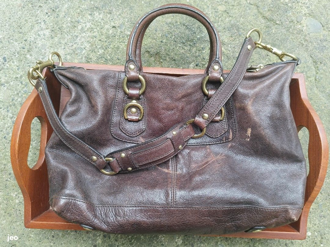 Coach Madison Sabrina Leather Satchel (Category: Luxury Bags & Wallets) located in Pavia. Submitted by deusk (Listing ID 1457088239, Image 2). Description: - Genuine brown leather Coach satchel - Features top handles and a detachable shoulder strap - Accented with classic brass hardware - Shows some signs of wear on leather edges and corners, consistent with pre-loved condition - A timeless and durable bag with plenty of use remaining.