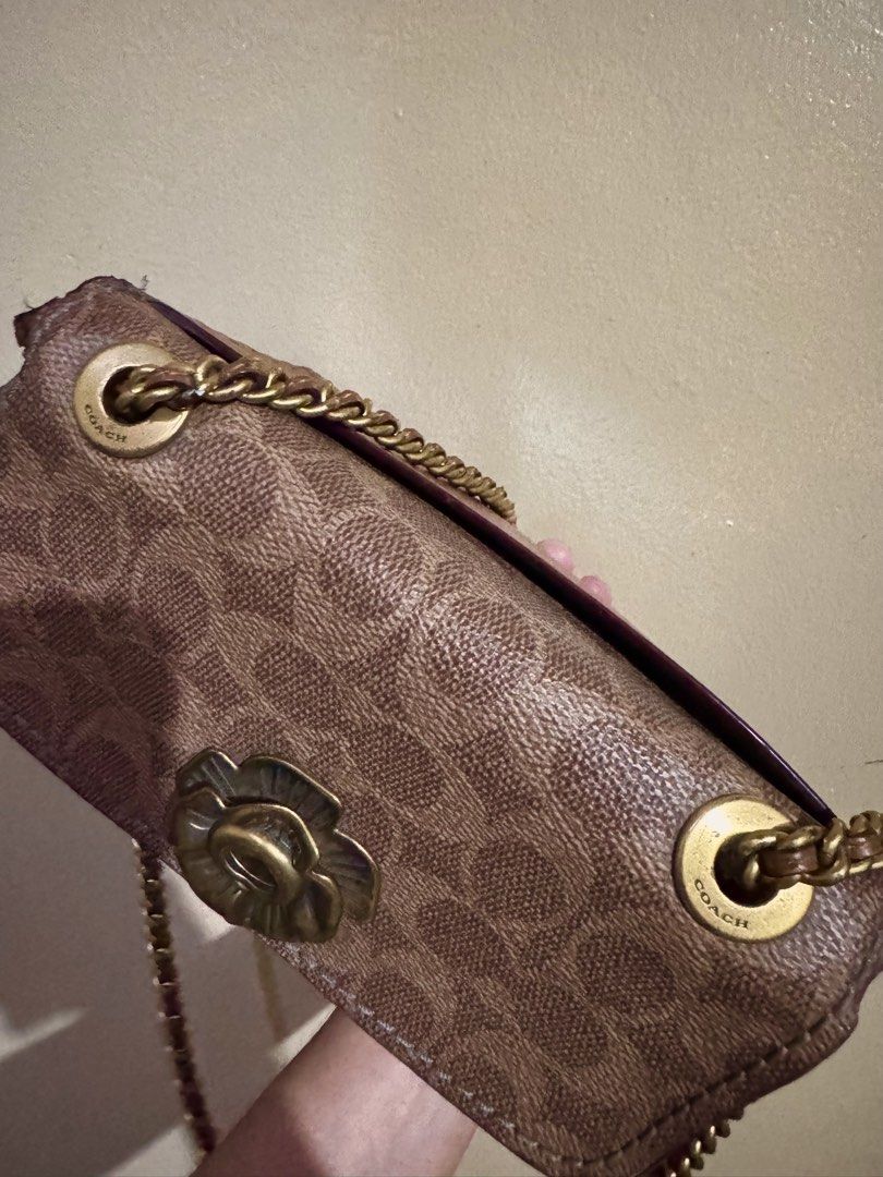 Coach Parker 18 Signature Canvas Rust (Category: Luxury Bags & Wallets) located in Santa Rosa. Submitted by justdecluterring_ (Listing ID 1457058481, Image 3). Description: - Authentic Coach Parker 18 bag - Signature coated canvas with rust-red leather base - Tea rose turnlock closure - Gold chain strap and stud details -Made in Philippines -Minimal issue.