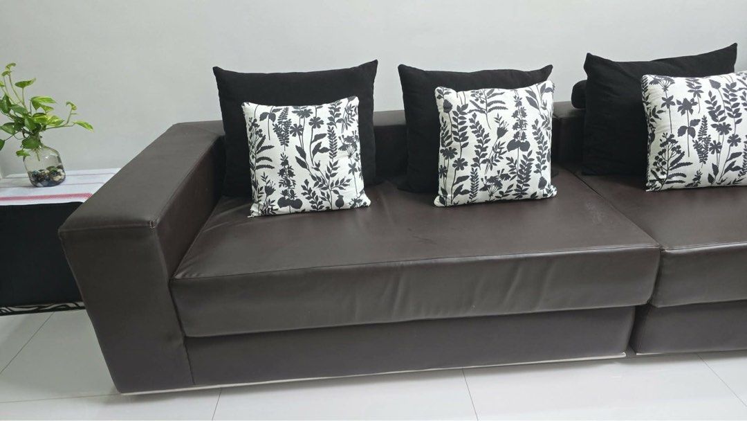 Dark Brown Leather L-Shaped Sofa with Cushions (Category: Sofas) located in Pasig City. Submitted by jvcanzon (Listing ID 1457104097, Image 2). Description: - Dark brown leather L-shaped sofa - Includes black and floral print cushions - Comfortably seats multiple people - Perfect for living rooms or lounges - Pick up only Size: Depth - 114cm Width - 320cm Height - 65cm Brand New price: 90k.