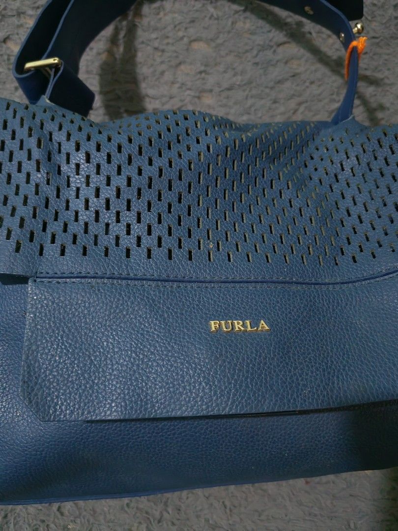 Furla Blue Leather Perforated Shoulder Bag (Category: Luxury Bags & Wallets) located in Las Pinas. Submitted by huslerz (Listing ID 1456991193, Image 2). Description: - Genuine blue leather Furla shoulder bag - Stylish perforated flap detail - Adjustable shoulder strap for comfort - Elegant gold-tone hardware - Minor scuffs on bottom corners, adding character - Ideal everyday bag for your essentials.