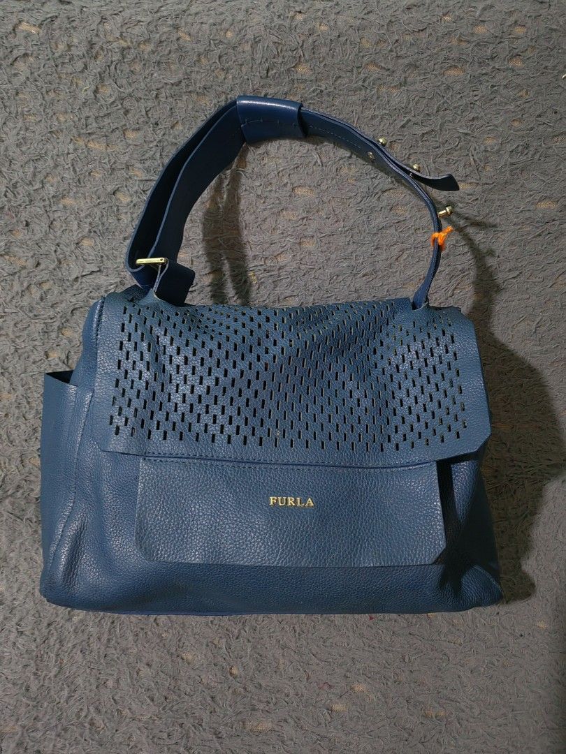 Furla Blue Leather Perforated Shoulder Bag (Category: Luxury Bags & Wallets) located in Las Pinas. Submitted by huslerz (Listing ID 1456991193, Image 1). Description: - Genuine blue leather Furla shoulder bag - Stylish perforated flap detail - Adjustable shoulder strap for comfort - Elegant gold-tone hardware - Minor scuffs on bottom corners, adding character - Ideal everyday bag for your essentials.