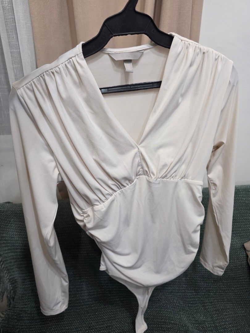 H&M Long Sleeve Ruched Bodysuit Cream (Category: Others Tops) located in Bulacan. Submitted by declutterwithme4 (Listing ID 1457005482, Image 1). Description: - H&M cream long sleeve bodysuit - Features a flattering ruched front detail - Convenient snap button closure at the bottom - Made from soft, comfortable fabric - Versatile piece for layering or wearing solo.