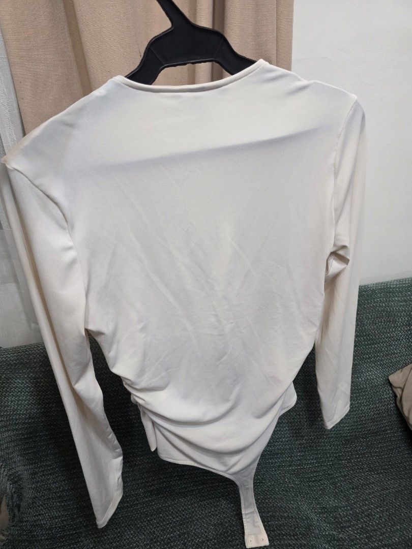 H&M Long Sleeve Ruched Bodysuit Cream (Category: Others Tops) located in Bulacan. Submitted by declutterwithme4 (Listing ID 1457005482, Image 2). Description: - H&M cream long sleeve bodysuit - Features a flattering ruched front detail - Convenient snap button closure at the bottom - Made from soft, comfortable fabric - Versatile piece for layering or wearing solo.