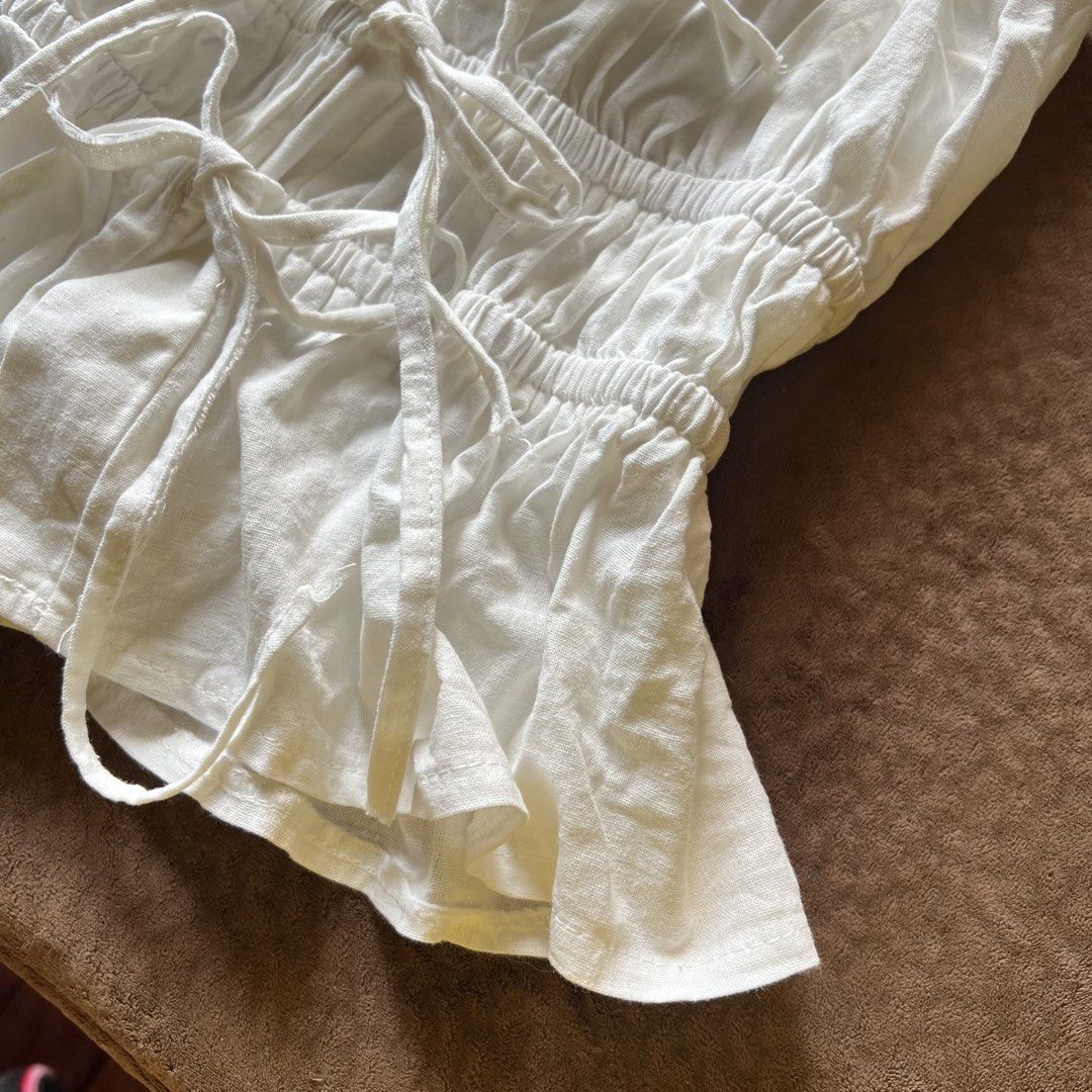 Linen ruched ribbon tie fitted top (Category: Sleeveless) located in Makati City. Submitted by monu__ (Listing ID 1456973201, Image 3). Description: Linen top Off white color, soft girl aesthetic Self tie / ribbon top Ruched, fitted, very stretchy, body hugging Adjustable U wont see skin underneath when tied which i loveee coz theres an inch of fabric from where the ties start (check last image) Size: small Shushi dupe! But butter imo.