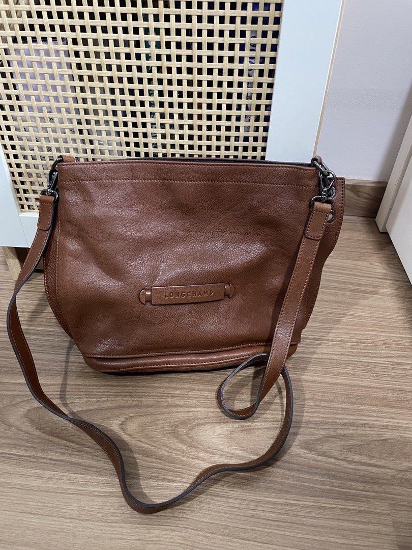 Longchamp Brown Leather Bucket Bag (Category: Luxury Bags & Wallets) located in Quezon City. Submitted by cm_preloved (Listing ID 1456987455, Image 1). Description: - Authentic brown leather Longchamp bucket/shoulder/crossbody bag - Main compartment with interior pockets - Adjustable strap - Includes original tags - Purchased from Rustan's - Original Retail Price: P35,500 - only flaw is the watermark on the exterior.