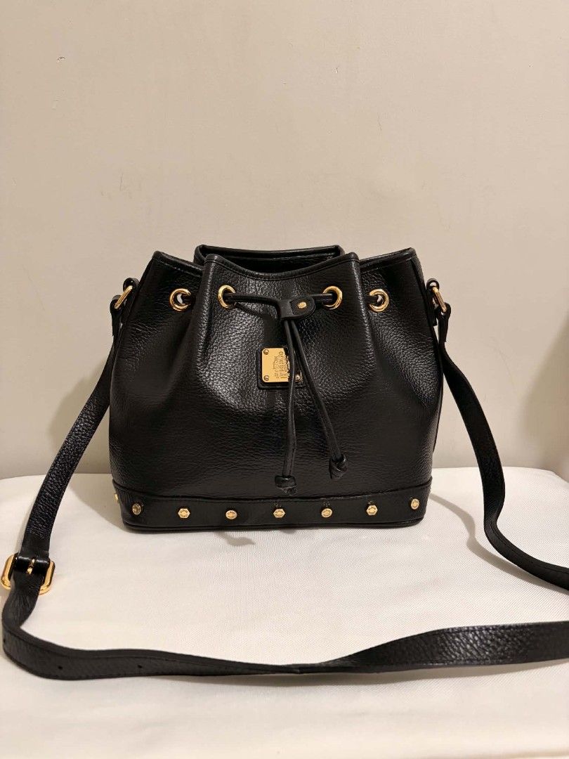 MCM Black Leather Studded Bucket Bag (Category: Luxury Bags & Wallets) located in San Pedro. Submitted by welloved.325 (Listing ID 1457057091, Image 1). Description: - Authentic MCM black leather bucket bag - Elegant gold hardware and stud details around the base - Secure drawstring closure - Adjustable shoulder strap for comfort - Ideal for everyday wear - Interior and exterior are clean - Ready for its new owner!.
