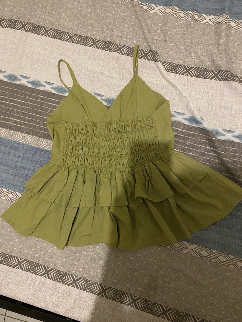 Olive Green Smocked Ruffle Camisole Top (Category: Sleeveless) located in Tanauan. Submitted by rie098 (Listing ID 1457061323, Image 2). Description: - Never worn - Cute olive green camisole top - Smocked back for a snug fit - Ruffle detailing on the hem - Versatile for casual outings or dressing up.