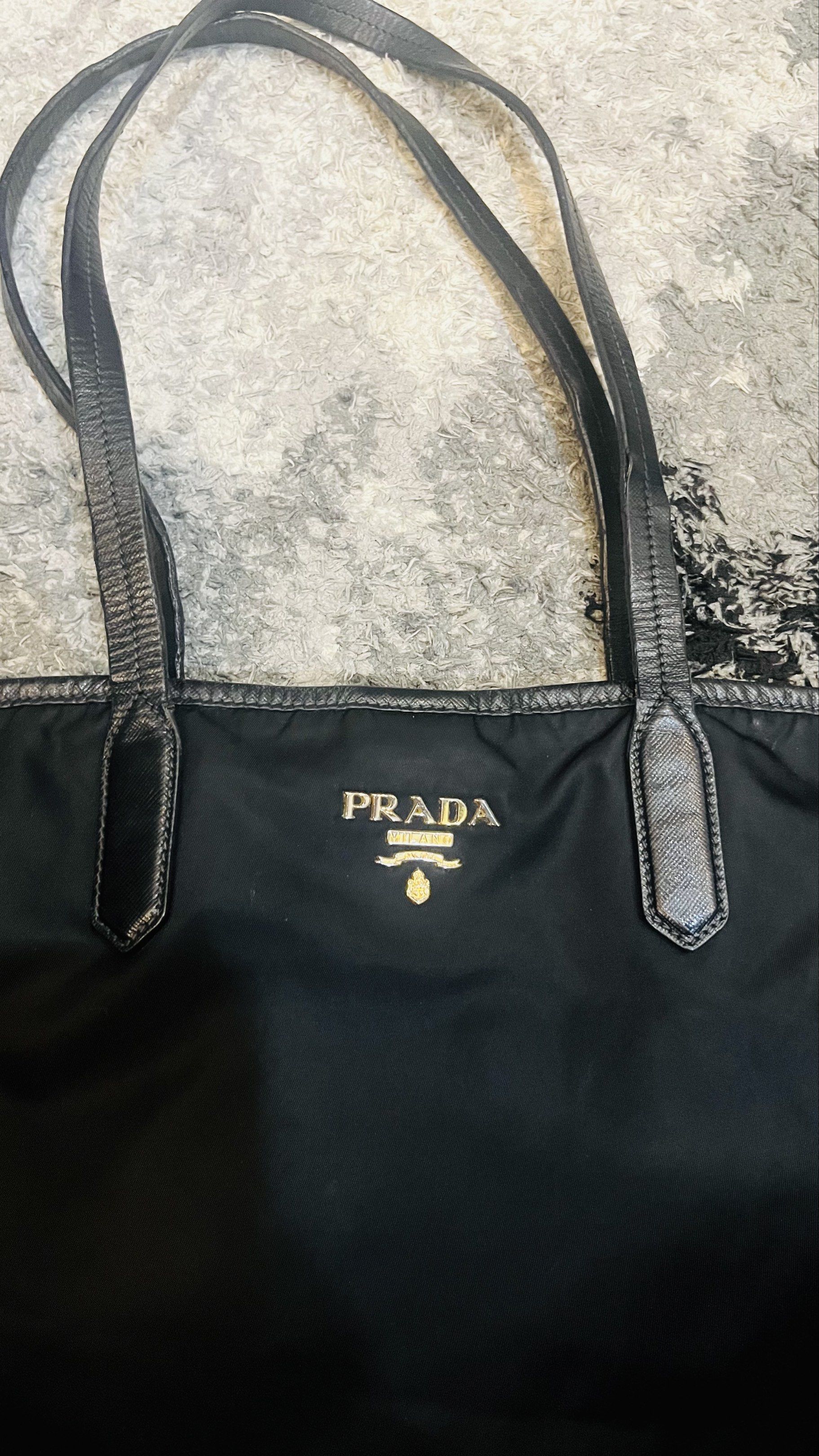 Prada Nylon Tessuto Tote Bag Black (Category: Luxury Bags & Wallets) located in Makati City. Submitted by jlohclaire (Listing ID 1457101939, Image 3). Description: - Authentic Prada tote bag - Color: Black - Material: Nylon with leather trim and handles - Features: Spacious interior - Origin: Made in Italy - Style: Classic and versatile for everyday use - this is a project Bag. Need to repair some part of the handle strap that that’s why I’m sell
