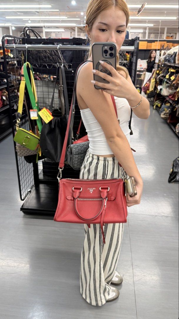 Prada Red Leather 2 way bag (Category: Luxury Bags & Wallets) located in Quezon City. Submitted by thirtyfinds (Listing ID 1457137851, Image 1). Description: 💯 Authentic - Crafted from luxurious textured leather - Secure zip closure - Convenient front zip pocket - Includes a detachable shoulder strap for versatile carrying - Durable and sturdy handles - Ideal for both everyday errands and elegant occasions - Bag is in good, pre-loved condition.