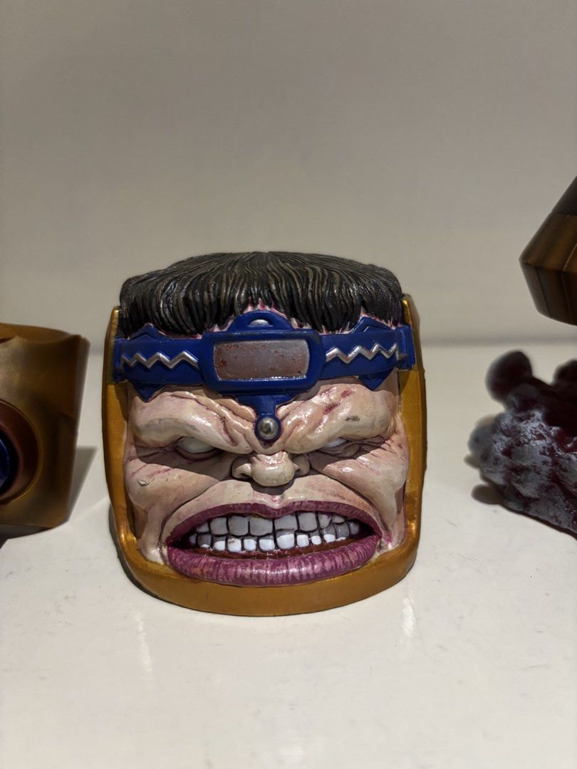[SET] Marvel Legends M.O.D.O.K. BAF Parts (Category: Figurines & Statues) located in Angeles City. Submitted by deyninazd (Listing ID 1457107440, Image 2). Description: The classic Marvel Legends M.O.D.O.K.! Great for collectors looking to complete the villain without buying individual figures. Included Parts: Head & Face Unit: High-detail angry expression sculpt, blue headband, and gold casing frame. Lower Chair & Legs: Metallic gold/bronze chai