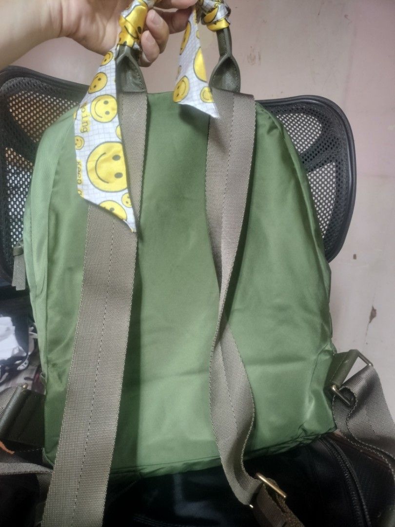 Tory Burch Olive Green Nylon Backpack with Smiley Scarf (Category: Backpacks) located in Cavite. Submitted by annasoriano1982 (Listing ID 1456991448, Image 2). Description: pls see handle my nag chops na pero hindi naman malala kaya my twilly sa front pocket my namumuti but not obvious as well kasya 13-14" inches laptop not guarantee kung sa patibayan lang mas matibay pa sya sa relasyon nyong mag jowa😁😁😁 ykk zip.