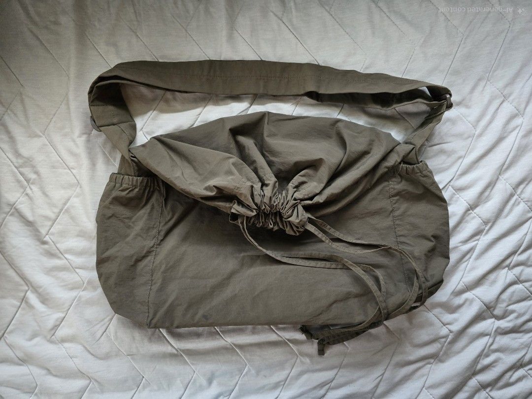 Uniqlo U Drawstring Shoulder Bag Olive Green (Category: Cross-body Bags) located in Mandaluyong City. Submitted by iemonte (Listing ID 1456959236, Image 1). Description: - Olive green messenger bag - Secure drawstring closure at the top - Convenient zippered pocket on the back - Two elasticated side pockets for easy access - Adjustable strap for comfortable carrying - Ideal for everyday adventures.