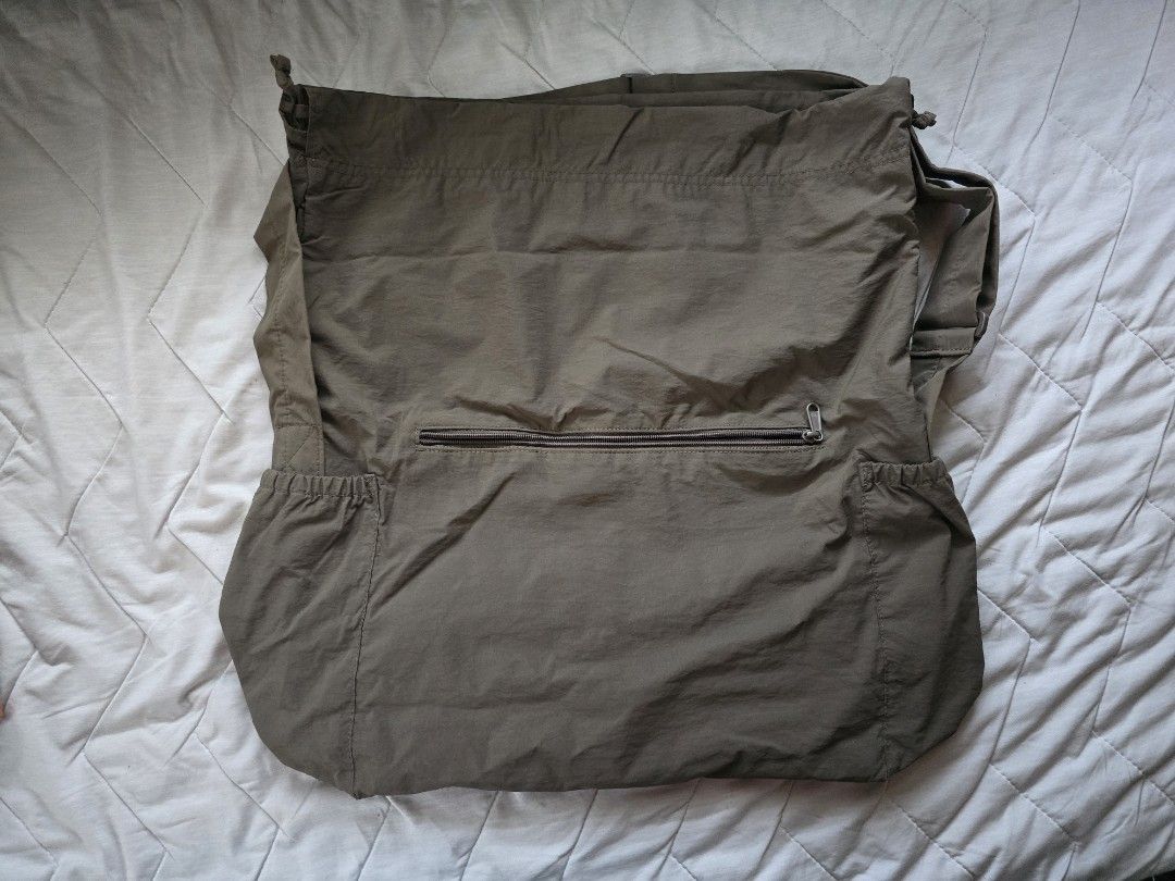 Uniqlo U Drawstring Shoulder Bag Olive Green (Category: Cross-body Bags) located in Mandaluyong City. Submitted by iemonte (Listing ID 1456959236, Image 2). Description: - Olive green messenger bag - Secure drawstring closure at the top - Convenient zippered pocket on the back - Two elasticated side pockets for easy access - Adjustable strap for comfortable carrying - Ideal for everyday adventures.