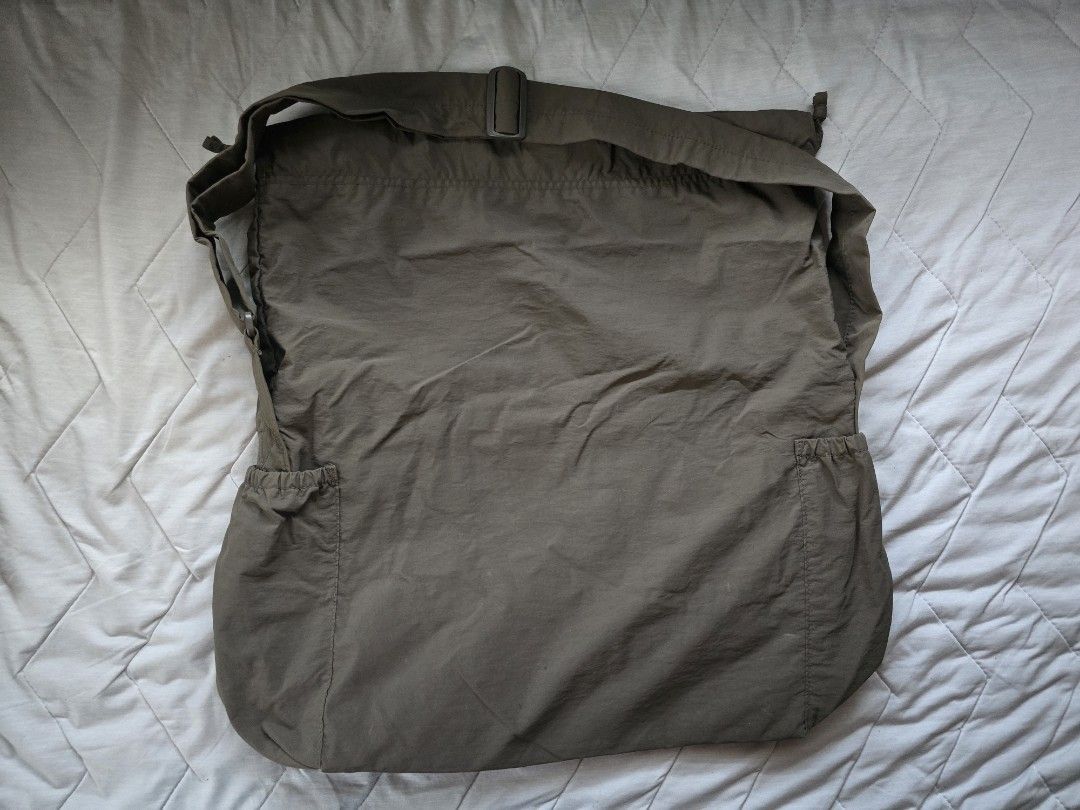 Uniqlo U Drawstring Shoulder Bag Olive Green (Category: Cross-body Bags) located in Mandaluyong City. Submitted by iemonte (Listing ID 1456959236, Image 3). Description: - Olive green messenger bag - Secure drawstring closure at the top - Convenient zippered pocket on the back - Two elasticated side pockets for easy access - Adjustable strap for comfortable carrying - Ideal for everyday adventures.