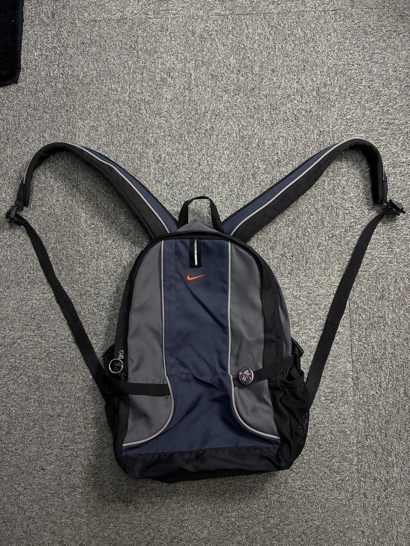VNTG NIKE Y2K BACKPACK (Category: Backpacks) located in Manila. Submitted by garahe_secretshop (Listing ID 1457122832, Image 1). Description: - Vintage Nike backpack - Y2K era style - Color: Navy blue and grey - Features side mesh pockets - Waterproof - Missing pullers -Expired reflectorized .