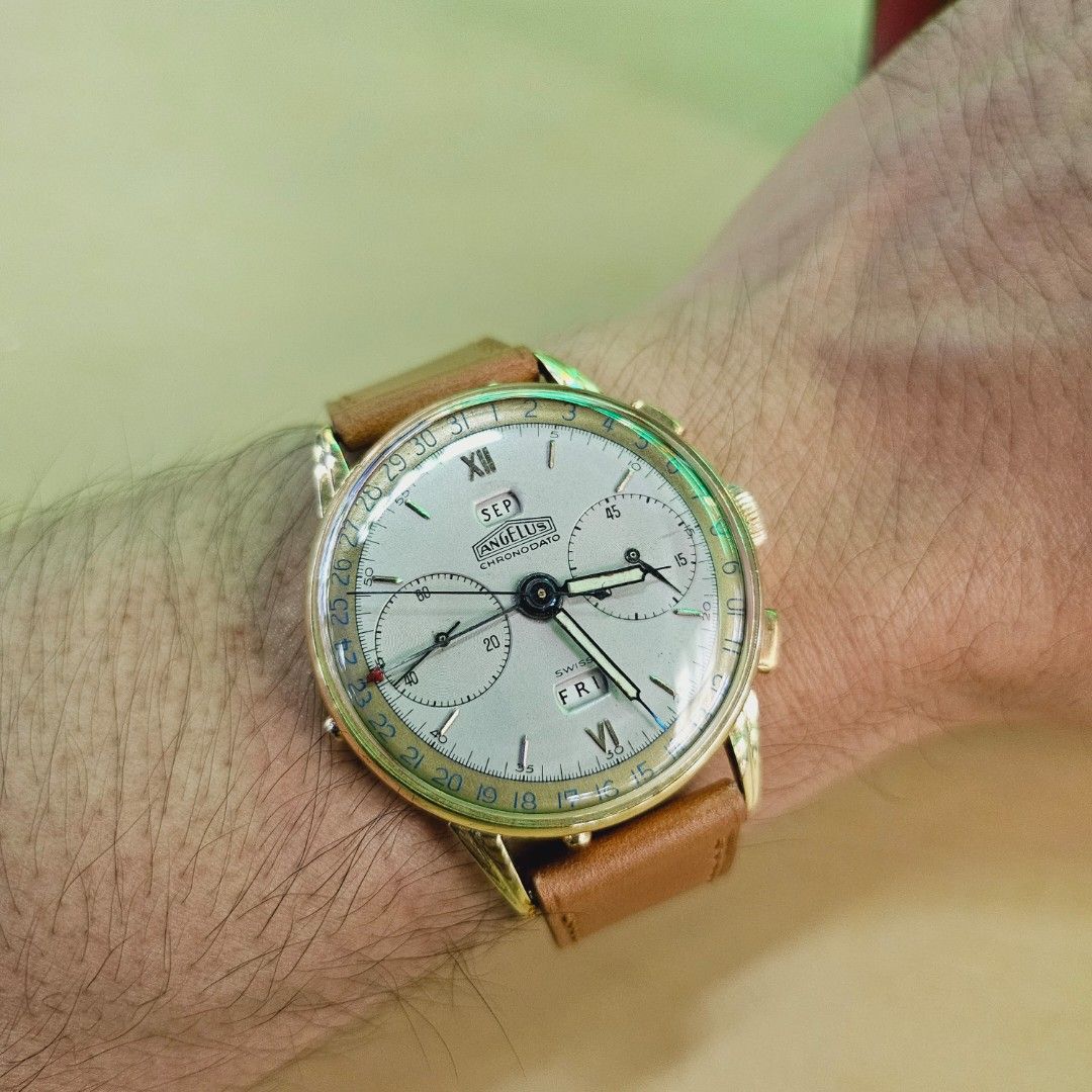 Angelus ChronoDato Triple Date Watch (Category: Watches) located in Singapore. Submitted by covetedluxury (Listing ID 1457284382, Image 1). Description: - Ultra Rare Vintage Angelus Chronodato is really well kept condition. - Triple Date complication (Day & Month windows) - Cream dial with applied indices - Sub-dials for chronograph functions - Comes with a brown leather strap -18k Gold Casing with generic tang buckle - Classic timepiece, ideal f