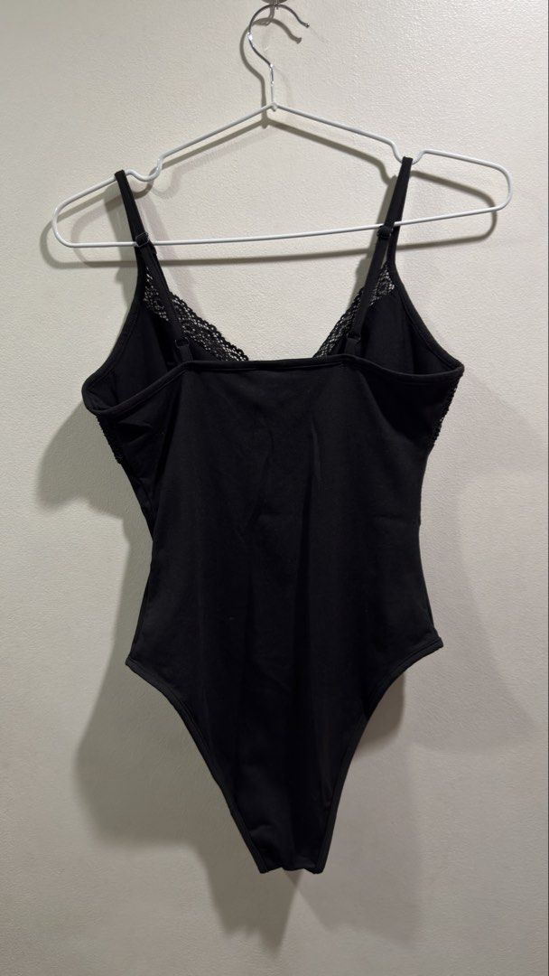 Black Lace Trim Bodysuit with Button Detail (Category: Others Tops) located in Cebu City. Submitted by ngl.prelovedstuff (Listing ID 1457156483, Image 2). Description: - Black bodysuit with delicate lace trim on bust and straps - Features a stylish button detail down the front - Adjustable straps for a perfect fit - Can be worn layered or as a standalone piece - Offers both comfort and a fashionable look.