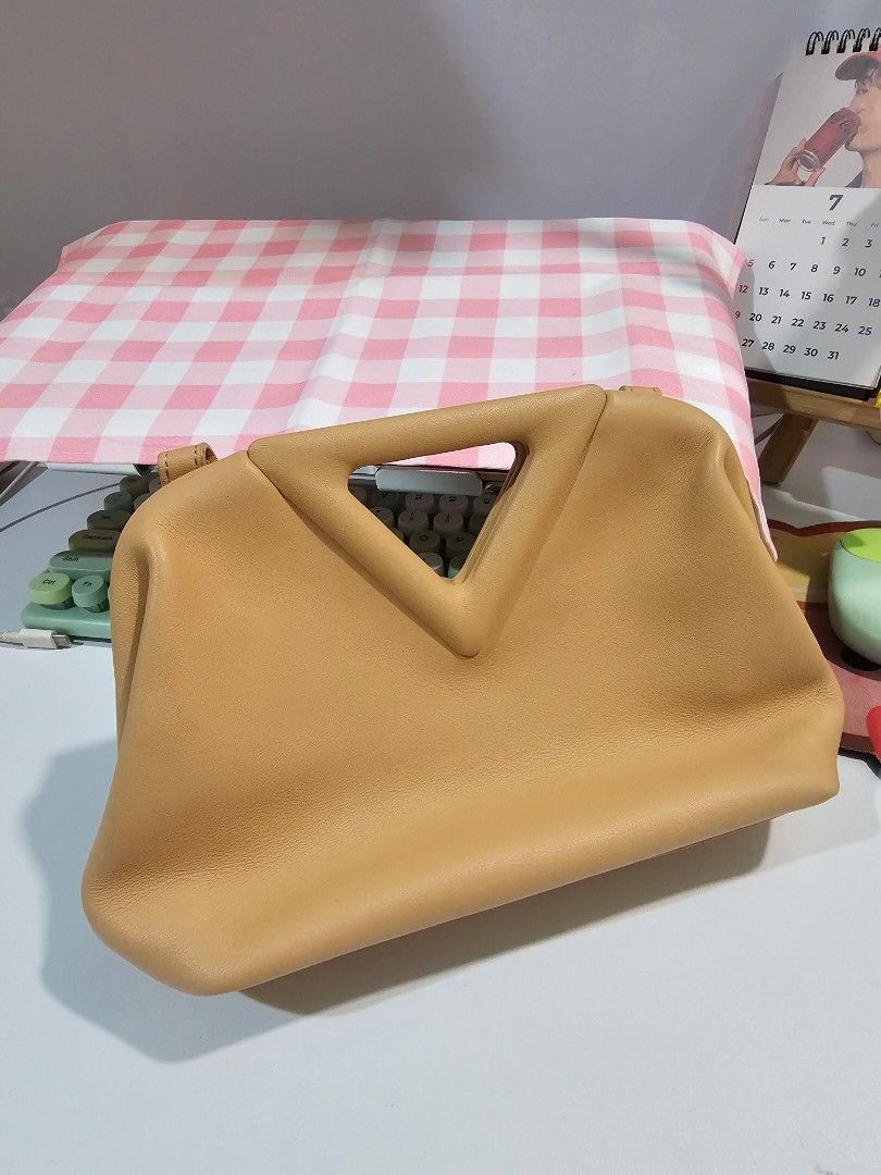 Bottega Veneta Pouch Bag (Category: Luxury Bags & Wallets) located in Manila. Submitted by violetjinnie (Listing ID 1457177788, Image 1). Description: - Tan leather pouch bag - Unique triangular handle - Detachable shoulder strap included - Interior: Bottega Veneta Made in Italy embossing - Versatile for day or night use.