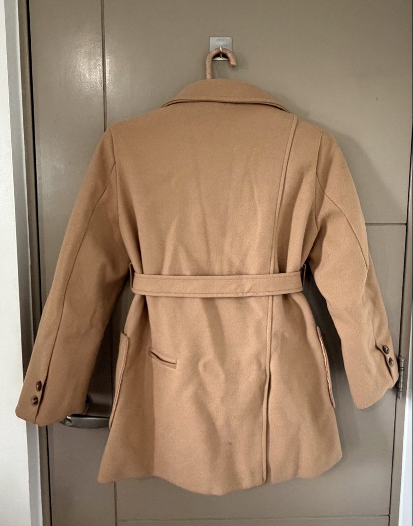 Brown winter coat (Category: Coats, Jackets and Outerwear) located in Manila. Submitted by lifestyle_declutter (Listing ID 1457170064, Image 2). Description: Price: Negotiable Orig price: Php 3k+ - Classic camel coat - Tie belt for adjustable fit - Lapel collar design - Quilted lining for warmth - Two functional front pockets - Button details on cuffs - Versatile for layering with jeans or dresses.