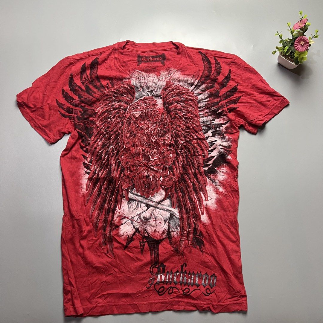 Buckaroo Red Graphic T-Shirt Eagle Wings Skull (Category: Tshirts & Polo Shirts ) located in Bago City. Submitted by g___shop (Listing ID 1457252490, Image 1). Description: - Red Buckaroo T-Shirt - Size: Medium (M) - Front Graphic: Large eagle with wings and skull design - Back Graphic: Buckaroo logo - Material: 100% Cotton - Style: Casual wear.