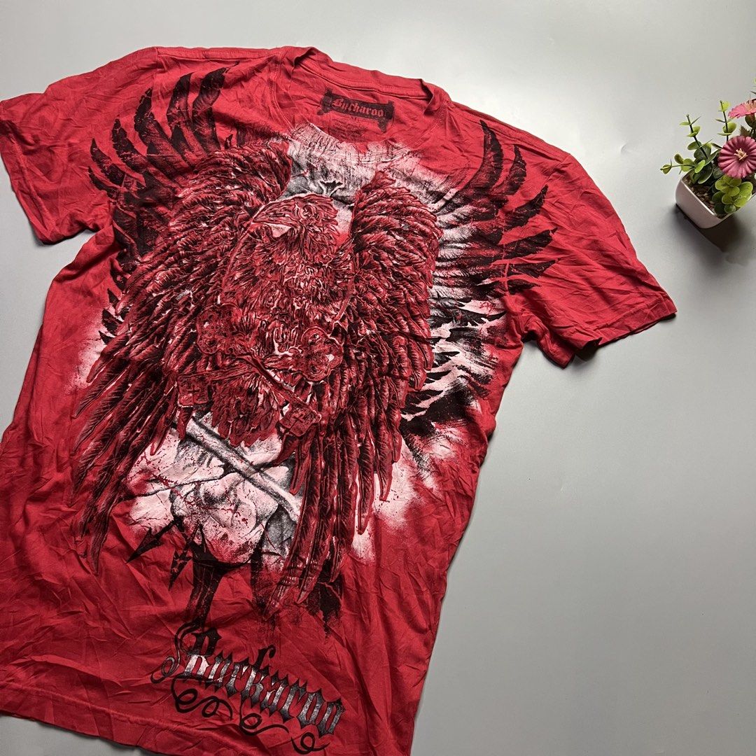 Buckaroo Red Graphic T-Shirt Eagle Wings Skull (Category: Tshirts & Polo Shirts ) located in Bago City. Submitted by g___shop (Listing ID 1457252490, Image 2). Description: - Red Buckaroo T-Shirt - Size: Medium (M) - Front Graphic: Large eagle with wings and skull design - Back Graphic: Buckaroo logo - Material: 100% Cotton - Style: Casual wear.