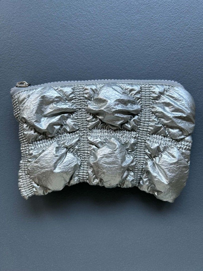 CARLYN Silver Puffy Pouch Bag (Category: Purses & Pouches) located in Calamba. Submitted by merrymerida (Listing ID 1457200878, Image 1). Description: - Cute puffy silver pouch from CARLYN - Features a crinkled texture - Ideal for small essentials (cards, cash, makeup) - Secure zipper closure - Approximate dimensions: 7" W x 4" H - Versatile use: as a clutch or bag organizer.
