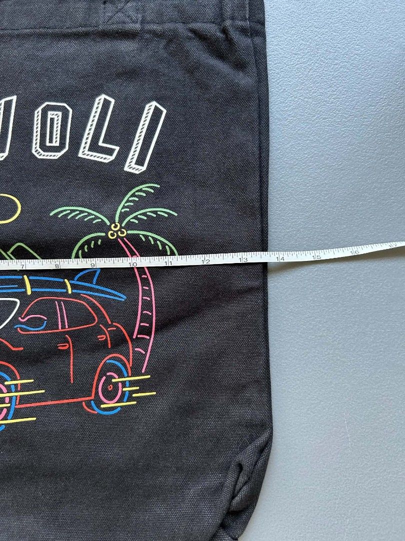 Covernat Tivoli Tote Bag (Category: Tote Bags) located in Calamba. Submitted by merrymerida (Listing ID 1457199649, Image 2). Description: - Brand: Covernat - Style: Black canvas tote bag - Design: Fun neon-style graphic with car, palm trees, surfboards, and 'TIVOLI' text - Features: Small inner pocket - Ideal for: Everyday use, beach trips, or casual outings.