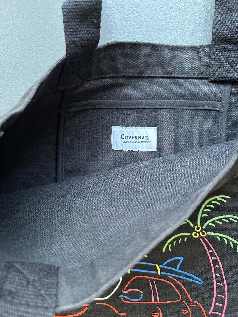 Covernat Tivoli Tote Bag (Category: Tote Bags) located in Calamba. Submitted by merrymerida (Listing ID 1457199649, Image 3). Description: - Brand: Covernat - Style: Black canvas tote bag - Design: Fun neon-style graphic with car, palm trees, surfboards, and 'TIVOLI' text - Features: Small inner pocket - Ideal for: Everyday use, beach trips, or casual outings.