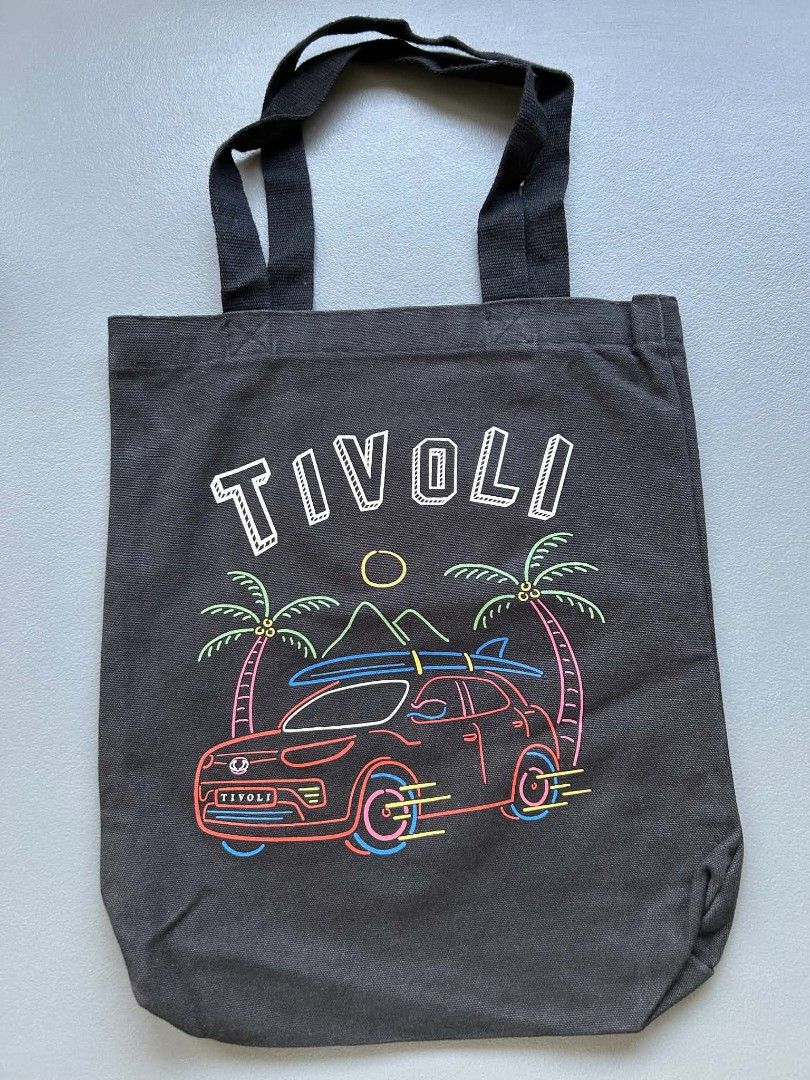 Covernat Tivoli Tote Bag (Category: Tote Bags) located in Calamba. Submitted by merrymerida (Listing ID 1457199649, Image 1). Description: - Brand: Covernat - Style: Black canvas tote bag - Design: Fun neon-style graphic with car, palm trees, surfboards, and 'TIVOLI' text - Features: Small inner pocket - Ideal for: Everyday use, beach trips, or casual outings.