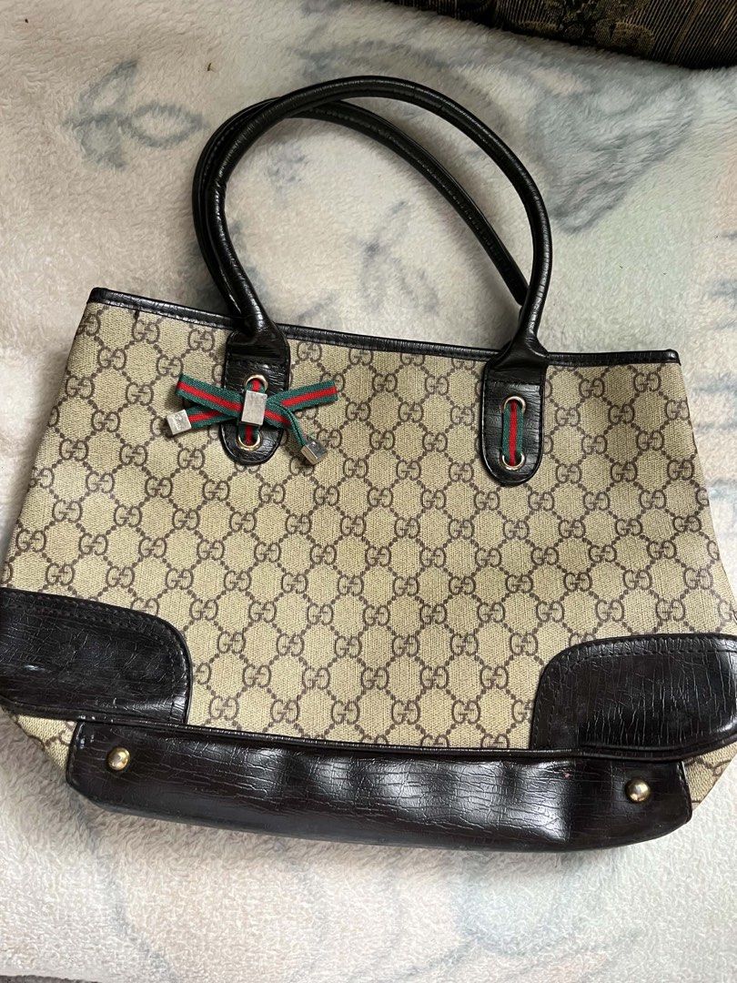 Gucci Monogram Canvas Leather Trim Tote Bag (Category: Luxury Bags & Wallets) located in Tayug. Submitted by eatingcakei (Listing ID 1457180787, Image 1). Description: - Classic Gucci tote bag - Beige GG monogram canvas with dark brown leather trim and handles - Multiple interior pockets for organization - Secure snap closure - Iconic Gucci ribbon detail on the front - Ideal everyday bag.