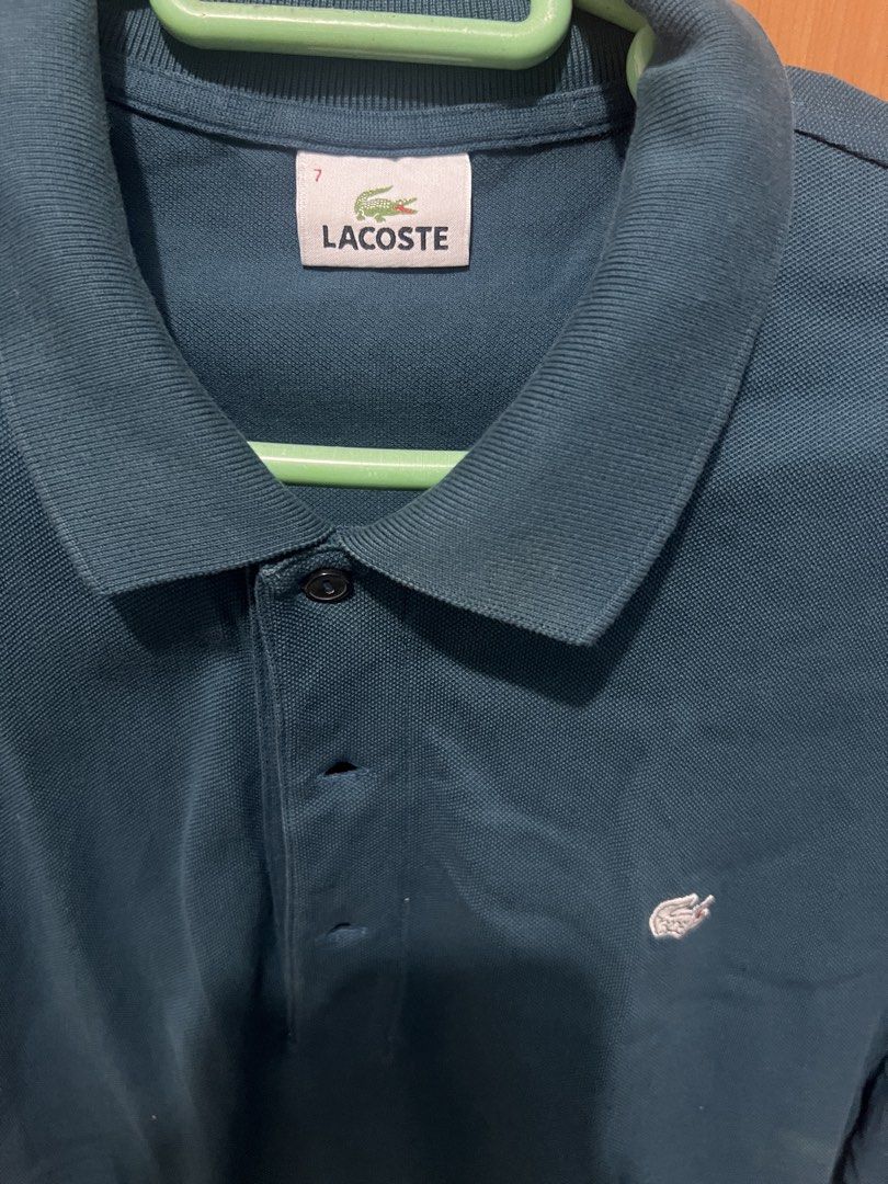 Lacoste Polo Shirt (Category: Tshirts & Polo Shirts ) located in Quezon City. Submitted by udzzz (Listing ID 1457222191, Image 2). Description: - Classic Lacoste polo shirt - Dark teal color - Iconic crocodile logo on chest - Button-up neckline - Size 7 - Ideal for casual or smart-casual wear.