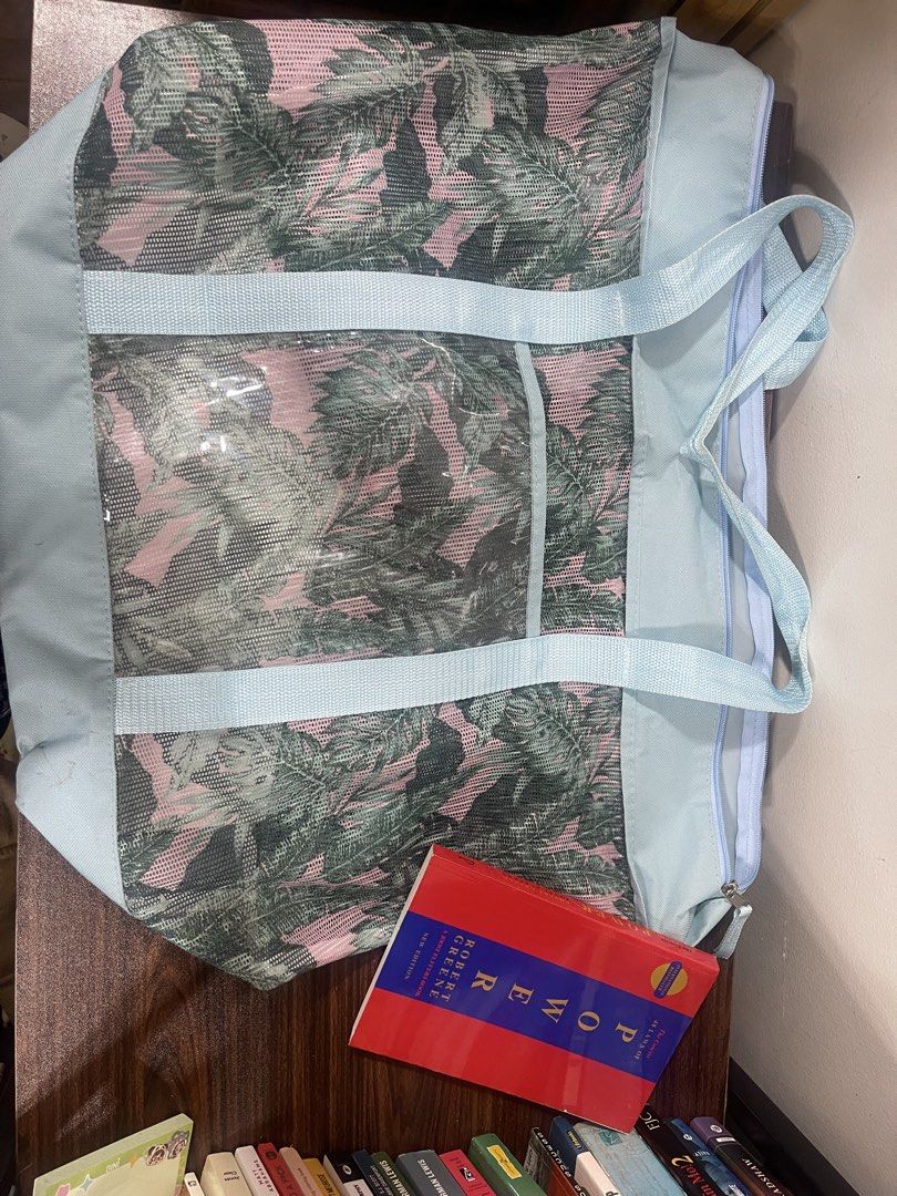 Light Blue Tropical Mesh Tote Bag with Clear Pockets (Category: Tote Bags) located in Makati City. Submitted by loushhh (Listing ID 1457320196, Image 1). Description: - Light blue tote bag - Tropical leaf print - Mesh exterior with clear pockets - Two light blue straps - Zipper closure - Ideal for beach days or errands.